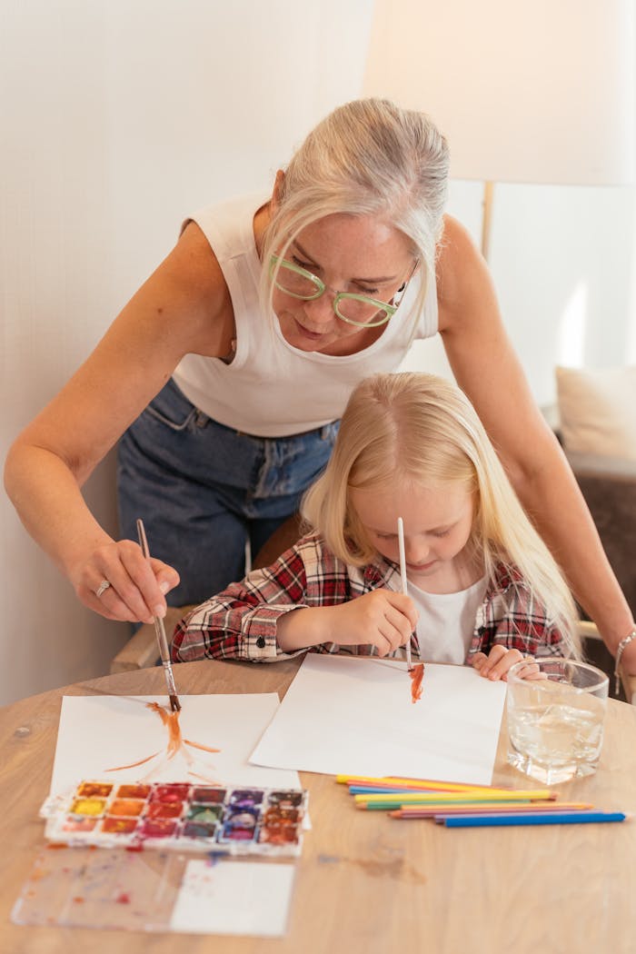 Home A senior woman and a young girl bond over a painting session using watercolors at home.